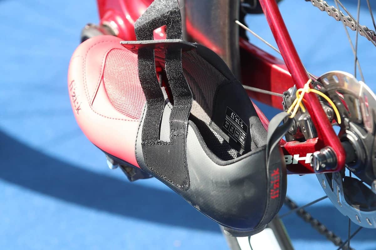 Detail cyklistické tretry s páskem na suchý zip zaklapnuté v nášlapném pedálu závodního kola
